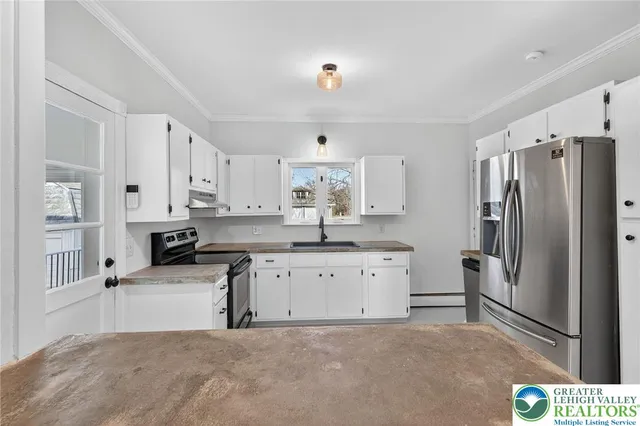 a kitchen with stainless steel appliances a refrigerator sink and cabinets