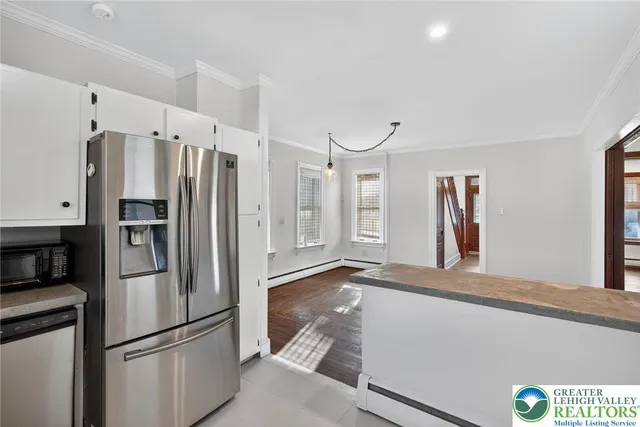 a kitchen with cabinets appliances and a wooden floor