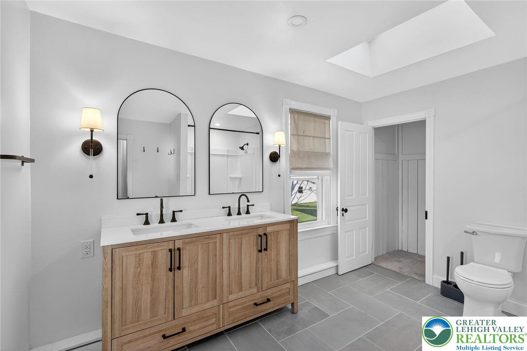 49 East Cherry Road Quakertown, PA 18951 - Photo 40 of 54 a spacious bathroom with a double vanity sink a mirror and a toilet
