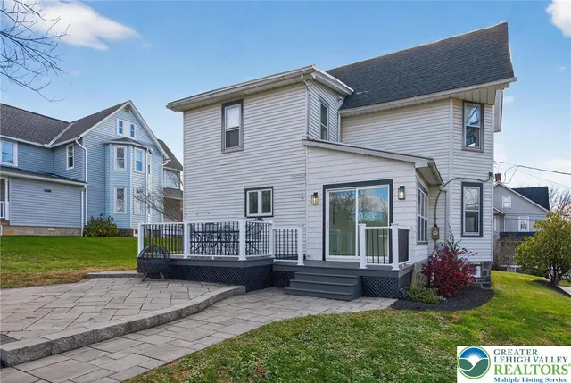 a view of a deck with table and chairs potted plants and large tree
