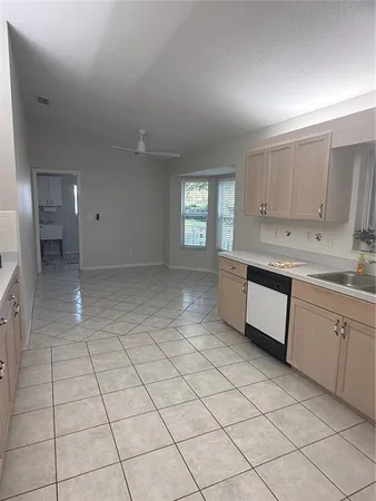 a kitchen with kitchen island a sink wooden floor and a window