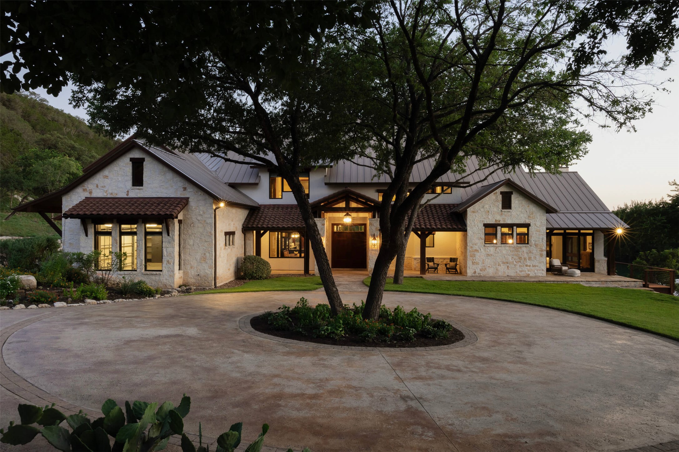 15016 Flat Top Ranch Road Austin, TX 78732 - Photo 39 of 40 Modern farmhouse style home featuring stone siding, curved driveway, a standing seam roof, and a metal roof