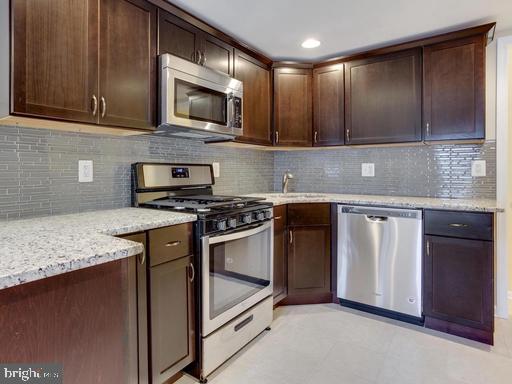 a kitchen with stainless steel appliances granite countertop a stove a microwave and a sink
