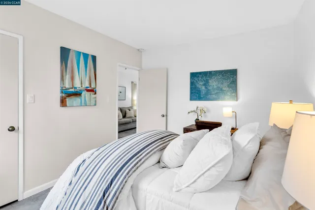 a bedroom with a bed and a painting on the wall