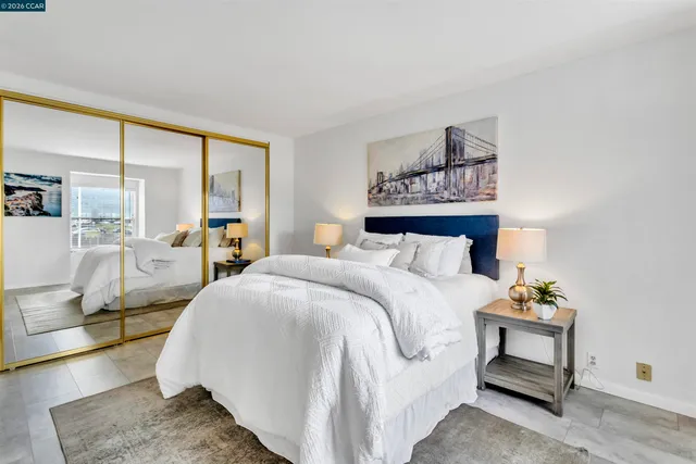 a bedroom with a large bed and wooden floor