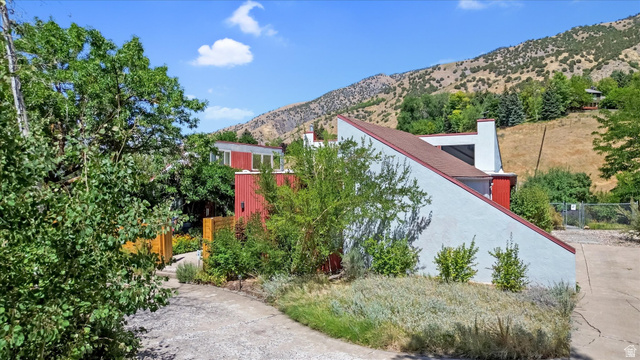 510 Spring Creek Road Providence, UT 84332 - Photo 70 of 97 Modern architectural design featuring a red and white exterior, a sloped roofline, a visible chimney, and mature landscaping