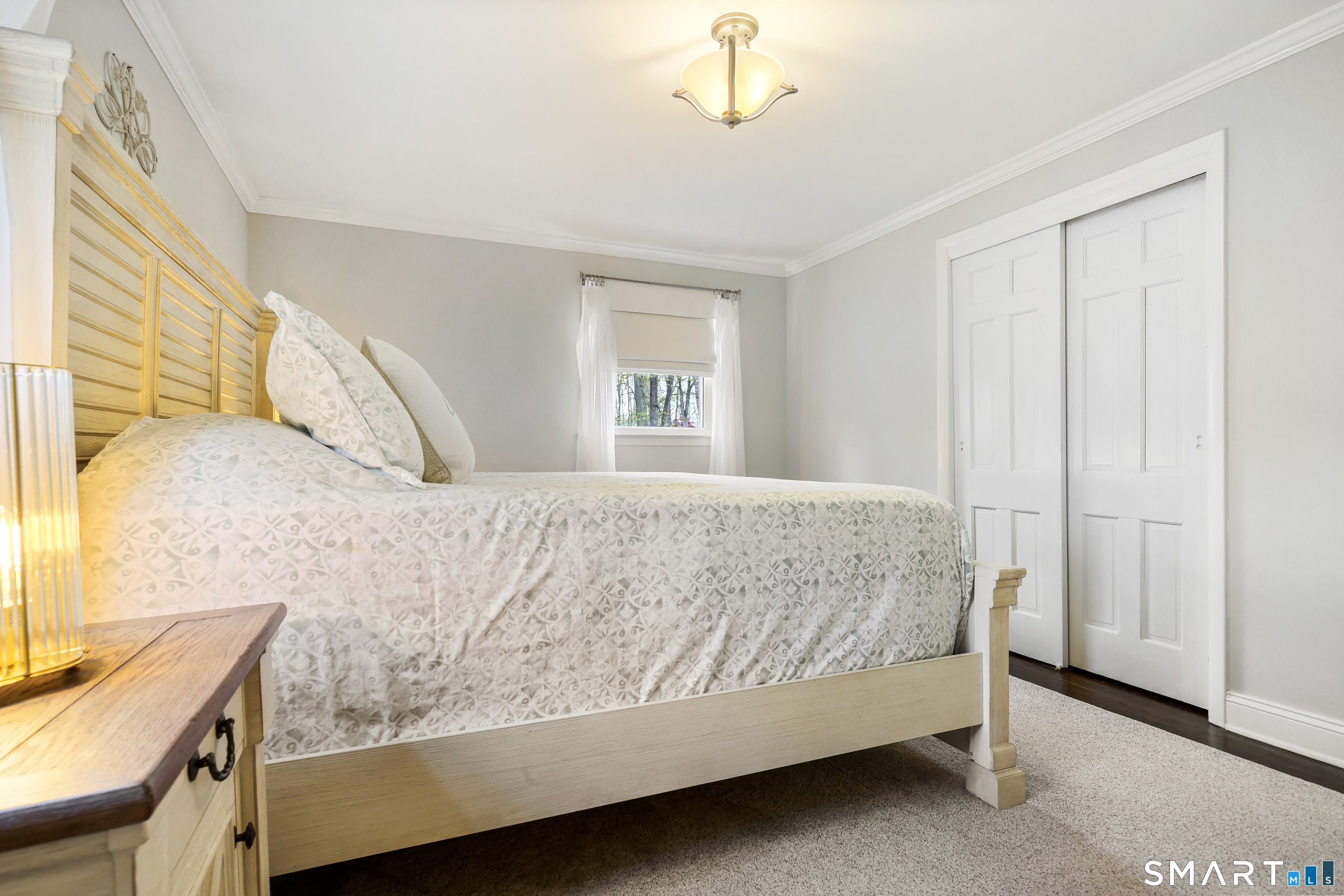 100 Flat Rock Drive Ridgefield, CT 06877 - Photo 16 of 40 a bedroom with a bed and a chandelier