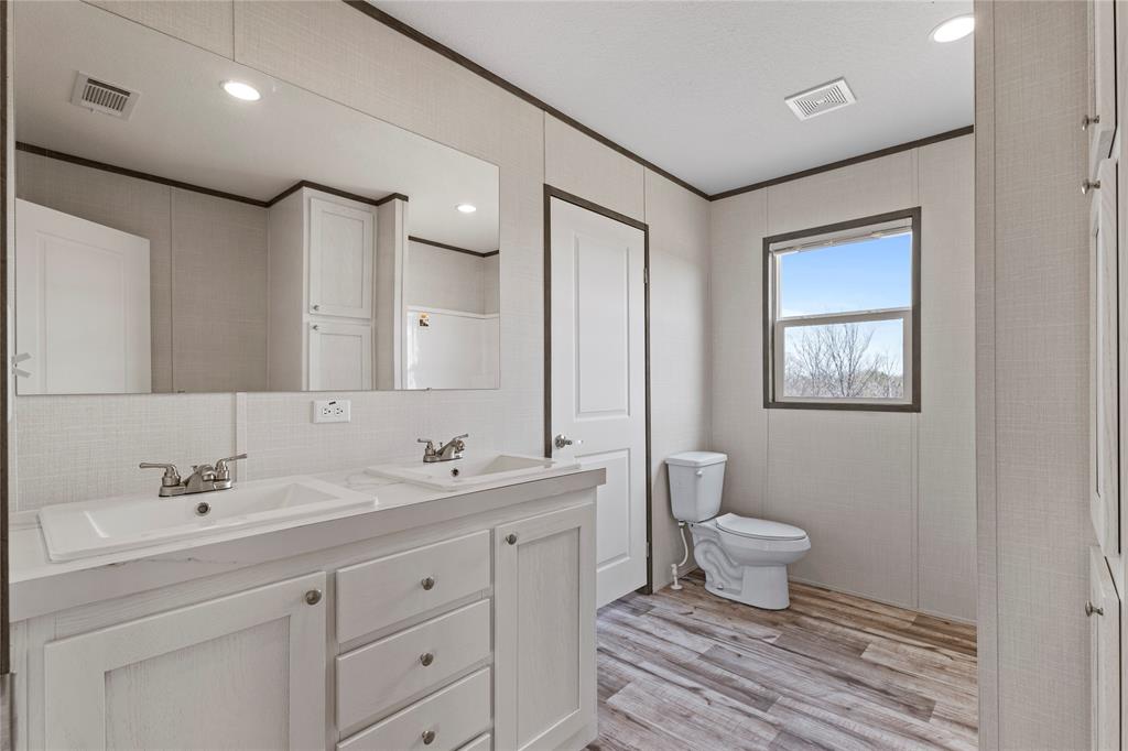 3924 Sandusky Road Whitesboro, TX 76273 - Photo 13 of 22 Bathroom featuring double vanity, ornamental molding, light wood-style flooring, recessed lighting, and tasteful backsplash