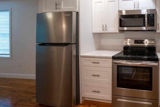 a kitchen with stainless steel appliances white cabinets and a stove