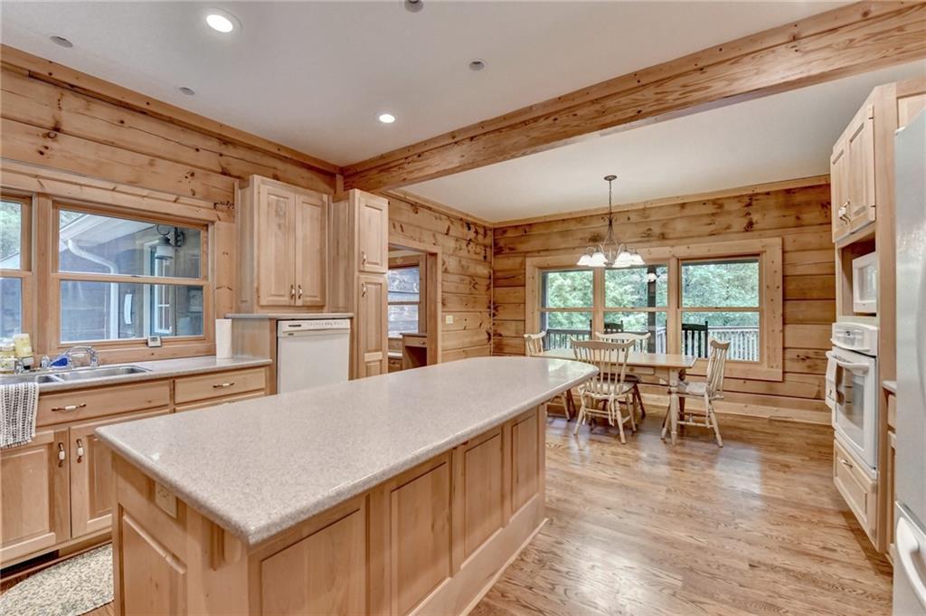 82 Walnut Grove Lane Tiger, GA 30576 - Photo 17 of 88 a kitchen with stainless steel appliances granite countertop a stove top oven a refrigerator a dining table and chairs with wooden floor