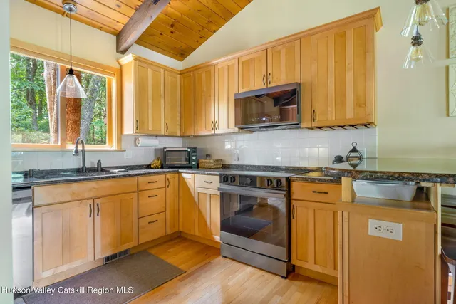 a kitchen with stainless steel appliances granite countertop a stove a sink and a microwave