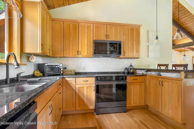 a kitchen with stainless steel appliances granite countertop a sink and a refrigerator
