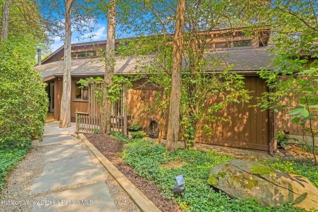a pathway of a house with a yard and sitting area