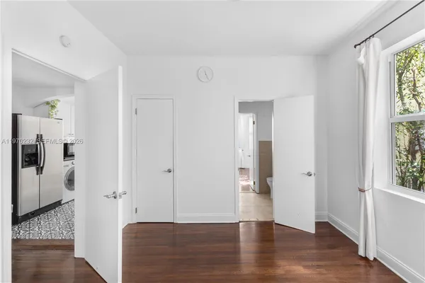 a view of a hallway with wooden floor and windows in a room