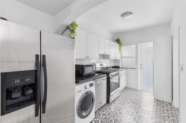 a kitchen with stainless steel appliances granite countertop a refrigerator a stove and a sink