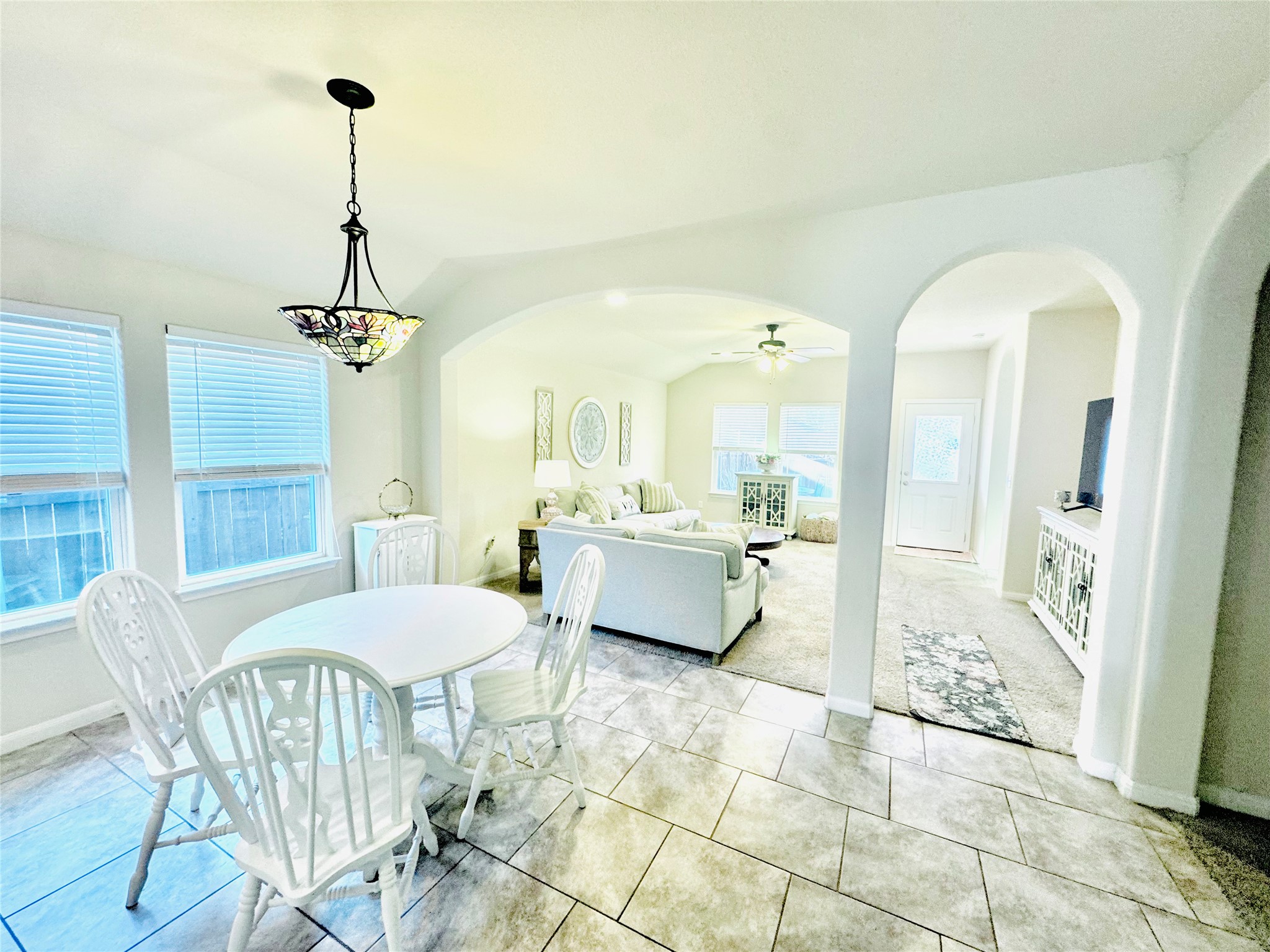 413 Gettysburg Loop Elgin, TX 78621 - Photo 13 of 32 Dining space featuring arched walkways, lofted ceiling, ceiling fan, and light tile patterned flooring
