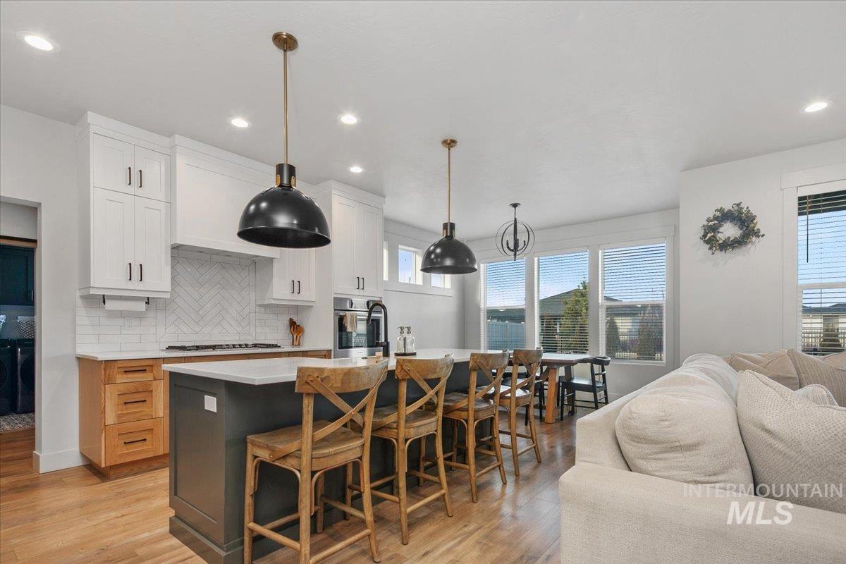 4150 East Fratello Street Meridian, ID 83642 - Photo 46 of 46 Kitchen featuring an island with sink, open floor plan, white cabinetry, backsplash, and recessed lighting