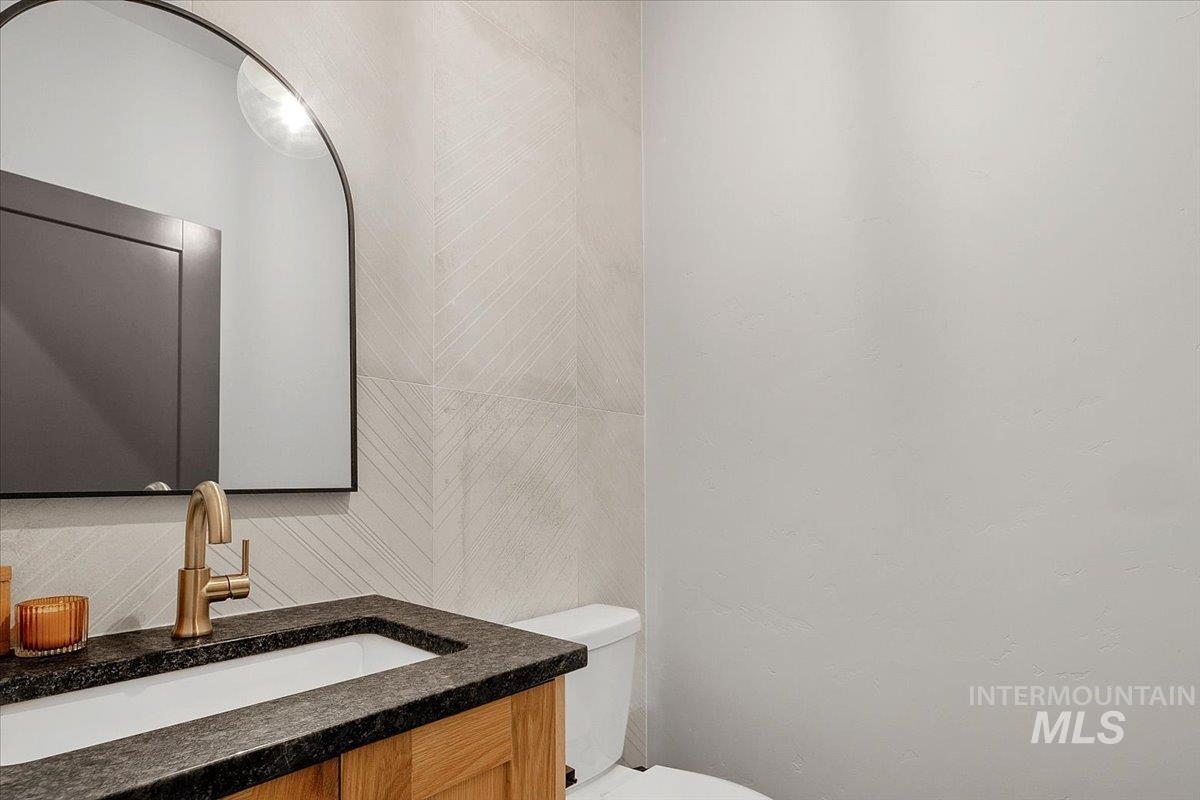 4150 East Fratello Street Meridian, ID 83642 - Photo 19 of 46 Half bath featuring vanity and decorative backsplash