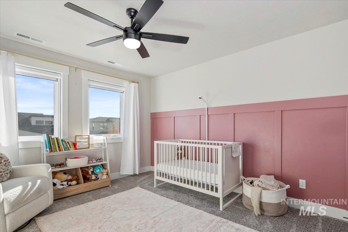 4150 East Fratello Street Meridian, ID 83642 - Photo 32 of 46 Bedroom with a decorative wall, a nursery area, ceiling fan, and light carpet
