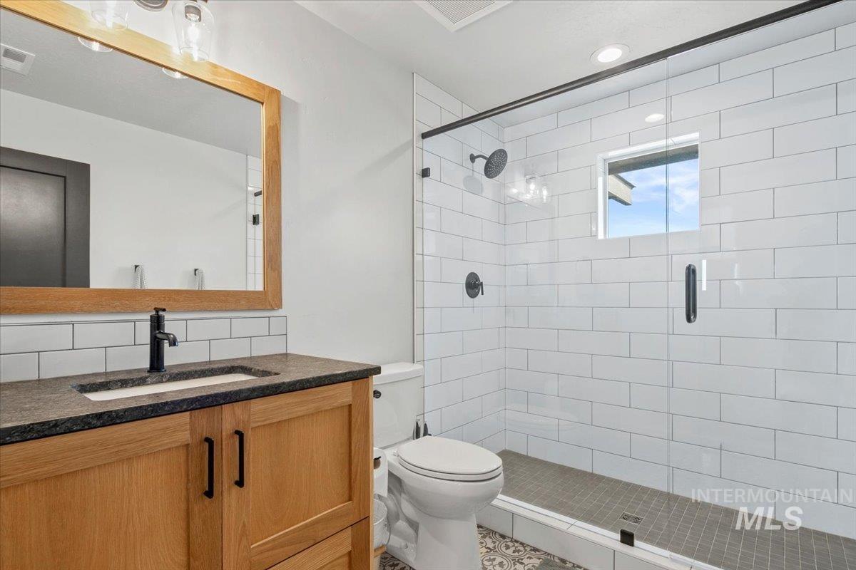 4150 East Fratello Street Meridian, ID 83642 - Photo 34 of 47 Bathroom featuring vanity, a shower stall, backsplash, and recessed lighting