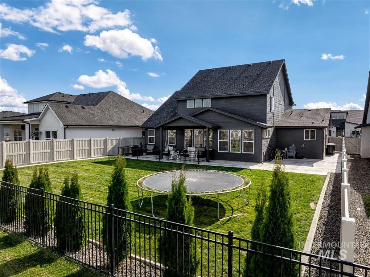 4150 East Fratello Street Meridian, ID 83642 - Photo 43 of 46 Back of property with a fenced backyard, a trampoline, a patio area, and a residential view