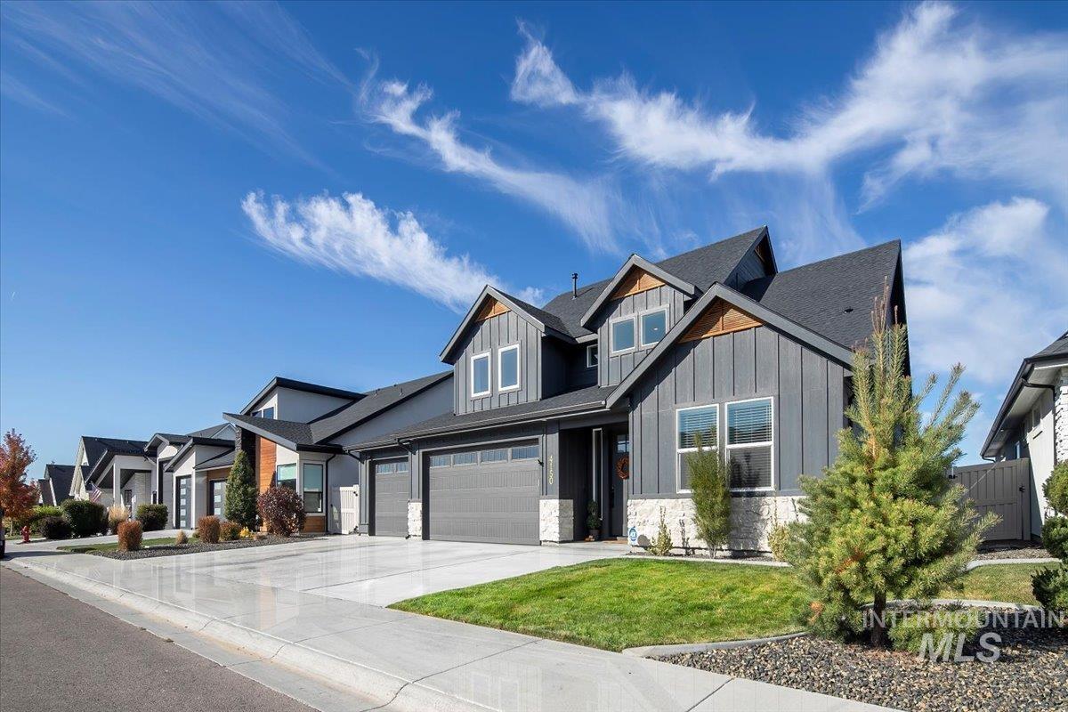 4150 East Fratello Street Meridian, ID 83642 - Photo 46 of 47 Craftsman inspired home featuring board and batten siding, concrete driveway, stone siding, a front yard, and a garage