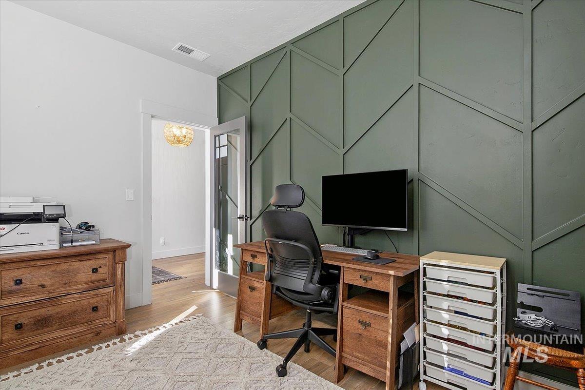 4150 East Fratello Street Meridian, ID 83642 - Photo 5 of 46 Office area with an accent wall, light wood-type flooring, a decorative wall, and a chandelier