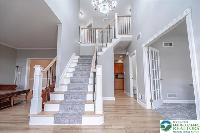 a kitchen with stainless steel appliances granite countertop a refrigerator a sink dishwasher a stove and a dining table with wooden floor