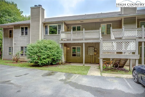 a front view of a house with garden and parking