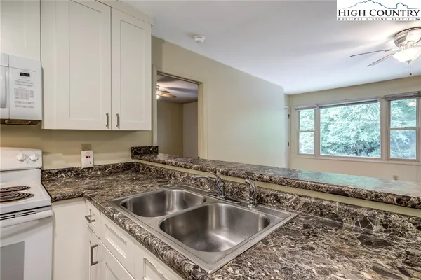 a kitchen with a sink cabinets and window