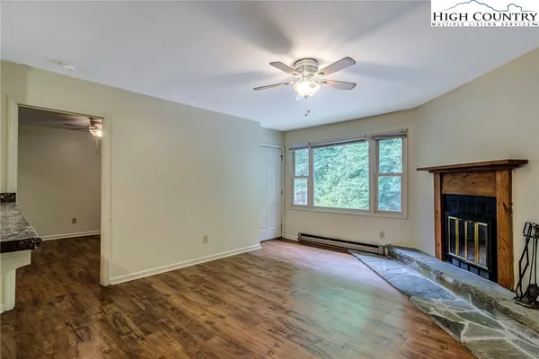 a view of an empty room with window and wooden floor