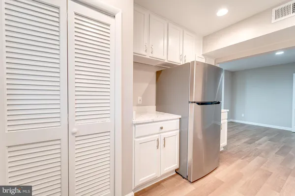a kitchen with cabinets and a refrigerator