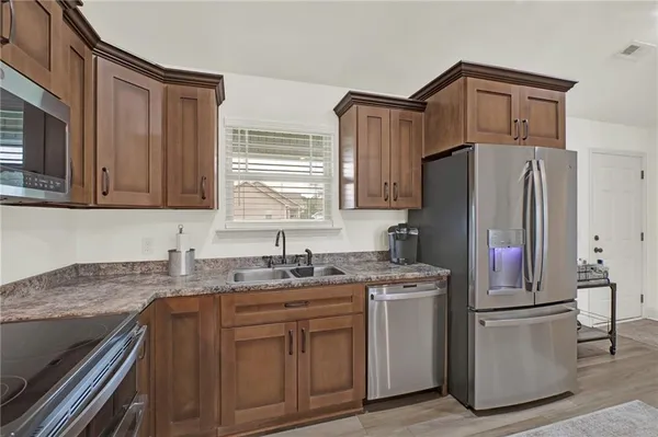 a kitchen with stainless steel appliances granite countertop a refrigerator sink and stove