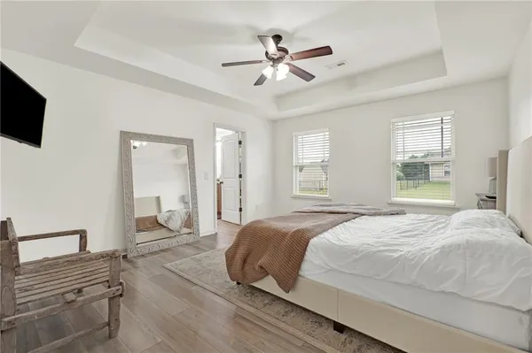 a bedroom with a large bed a flat tv screen and furniture