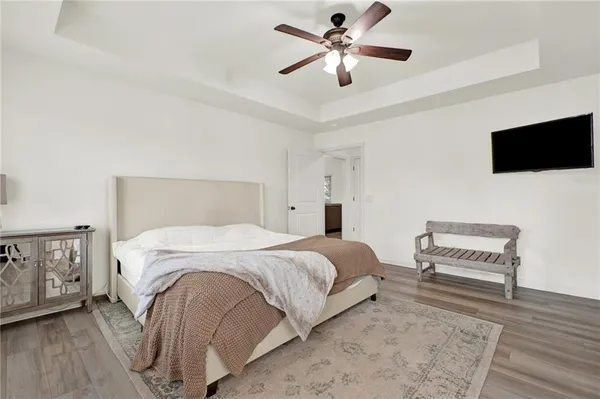 a bedroom with a bed a chandelier and a dresser