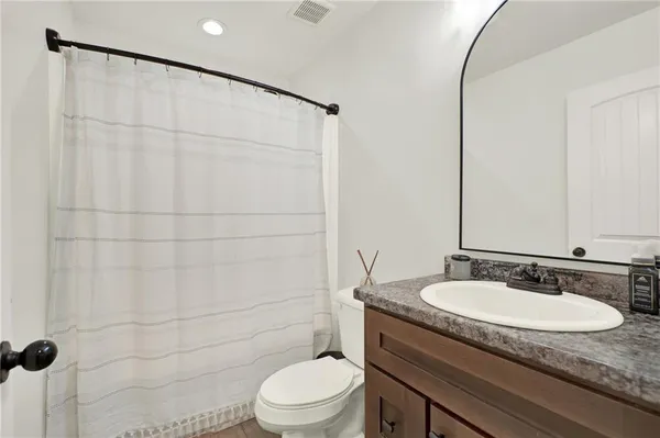 a bathroom with a granite countertop sink toilet and shower