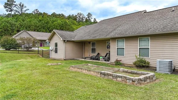 a view of a house with a backyard and a tree