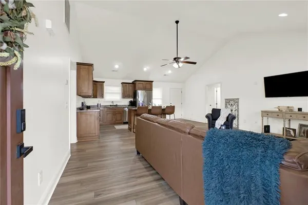 a living room with stainless steel appliances kitchen island granite countertop furniture a fireplace and a flat screen tv