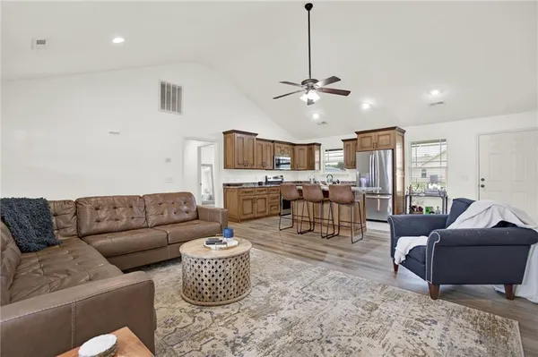 a living room with furniture kitchen view and a chandelier