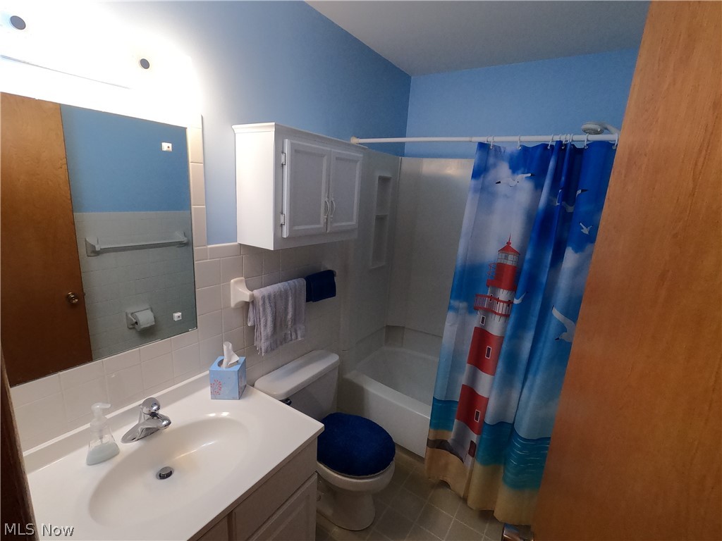 2586 Batdorf Road Wooster, OH 44691 - Photo 11 of 33 Full bathroom featuring tile floors, tile walls, tasteful backsplash, shower / bath combination with curtain, and toilet