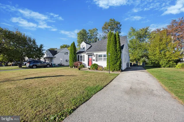 a front view of a house with a yard and trees