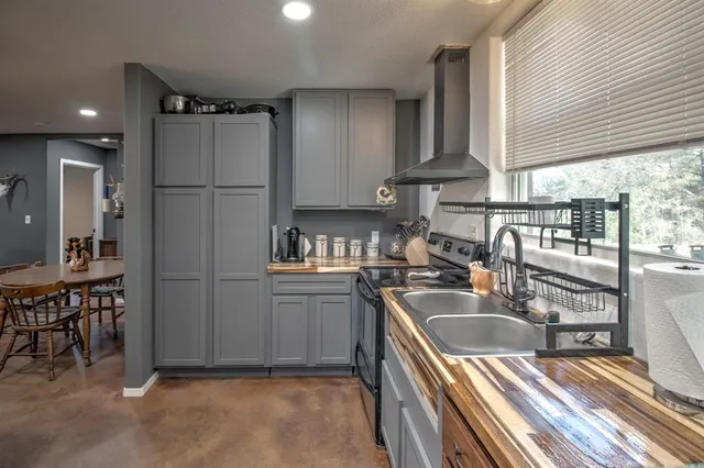 a kitchen that has a lot of cabinets a sink and appliances