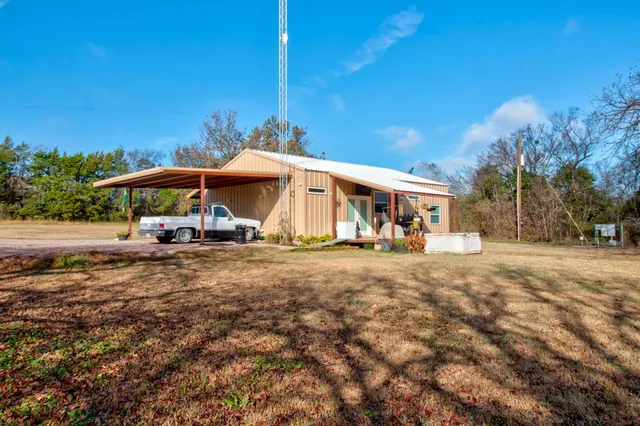 a view of a house with backyard and a tree