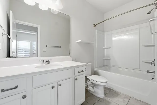 a bathroom with a toilet a sink a mirror a bathtub and vanity