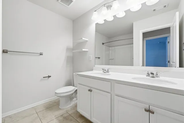 a bathroom with a toilet a sink a mirror and vanity