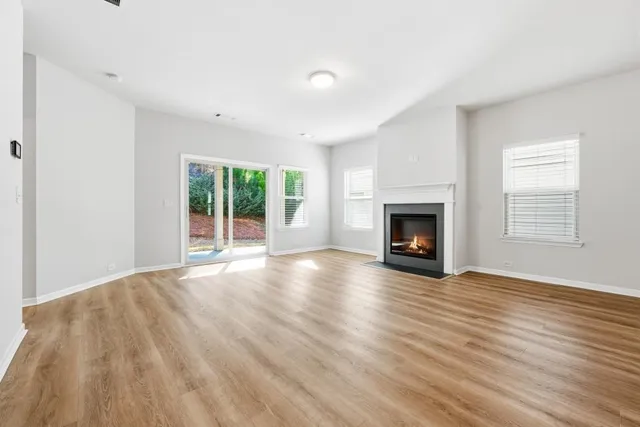 a view of empty room with wooden floor and fireplace