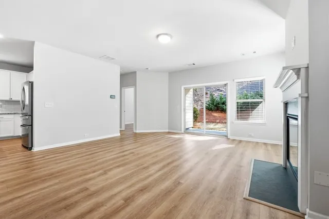 an empty room with wooden floor and a fireplace