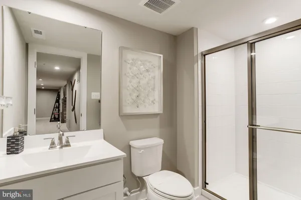 a bathroom with a sink mirror vanity and toilet