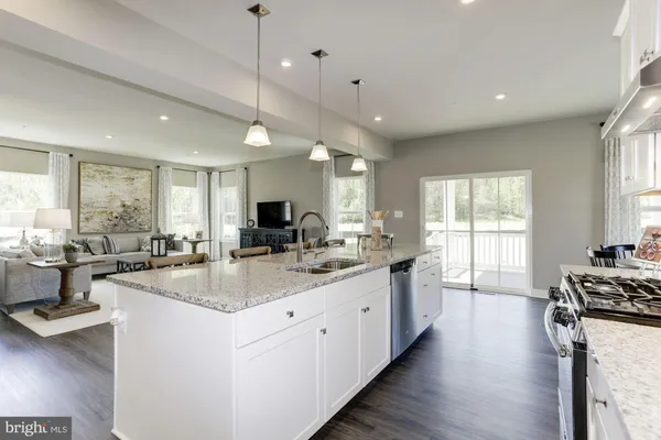 a large kitchen with kitchen island lots of counter space a sink appliances and a window