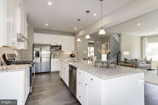 a kitchen with stainless steel appliances granite countertop a sink a stove and a refrigerator